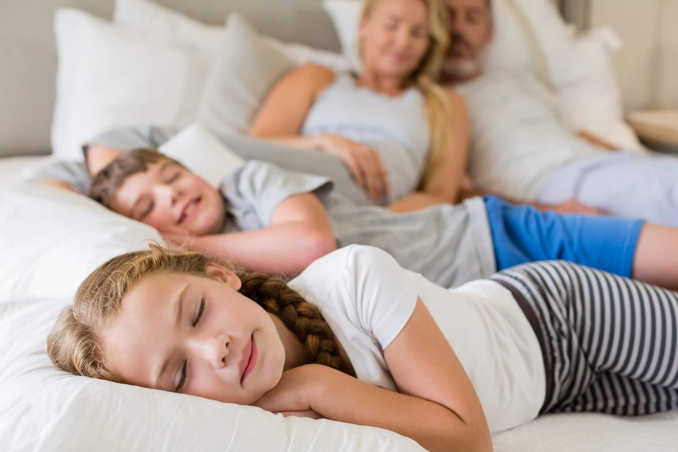 Eltern und Kinder schlafen auf dem Bett im Schlafzimmer