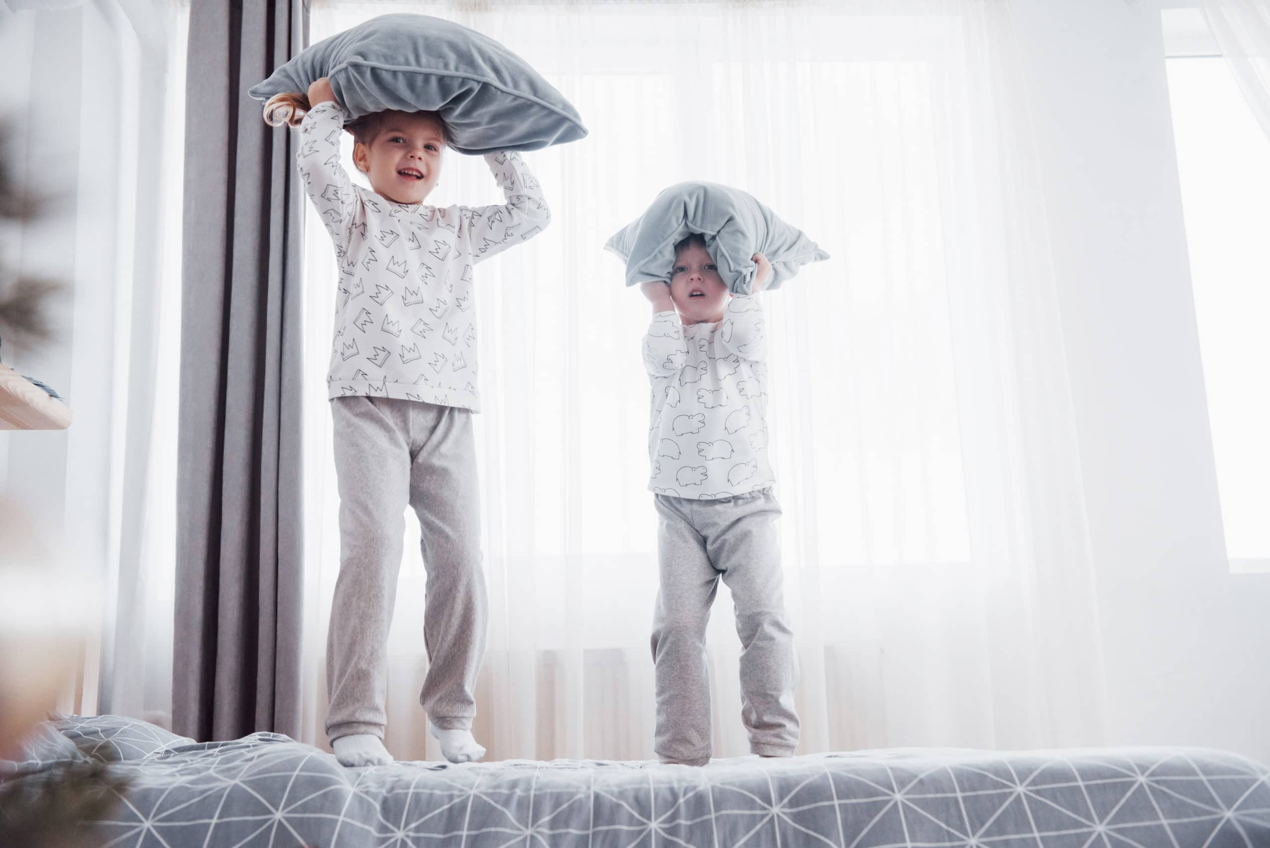 Kinder in weichen warmen Schlafanzug spielen im Bett