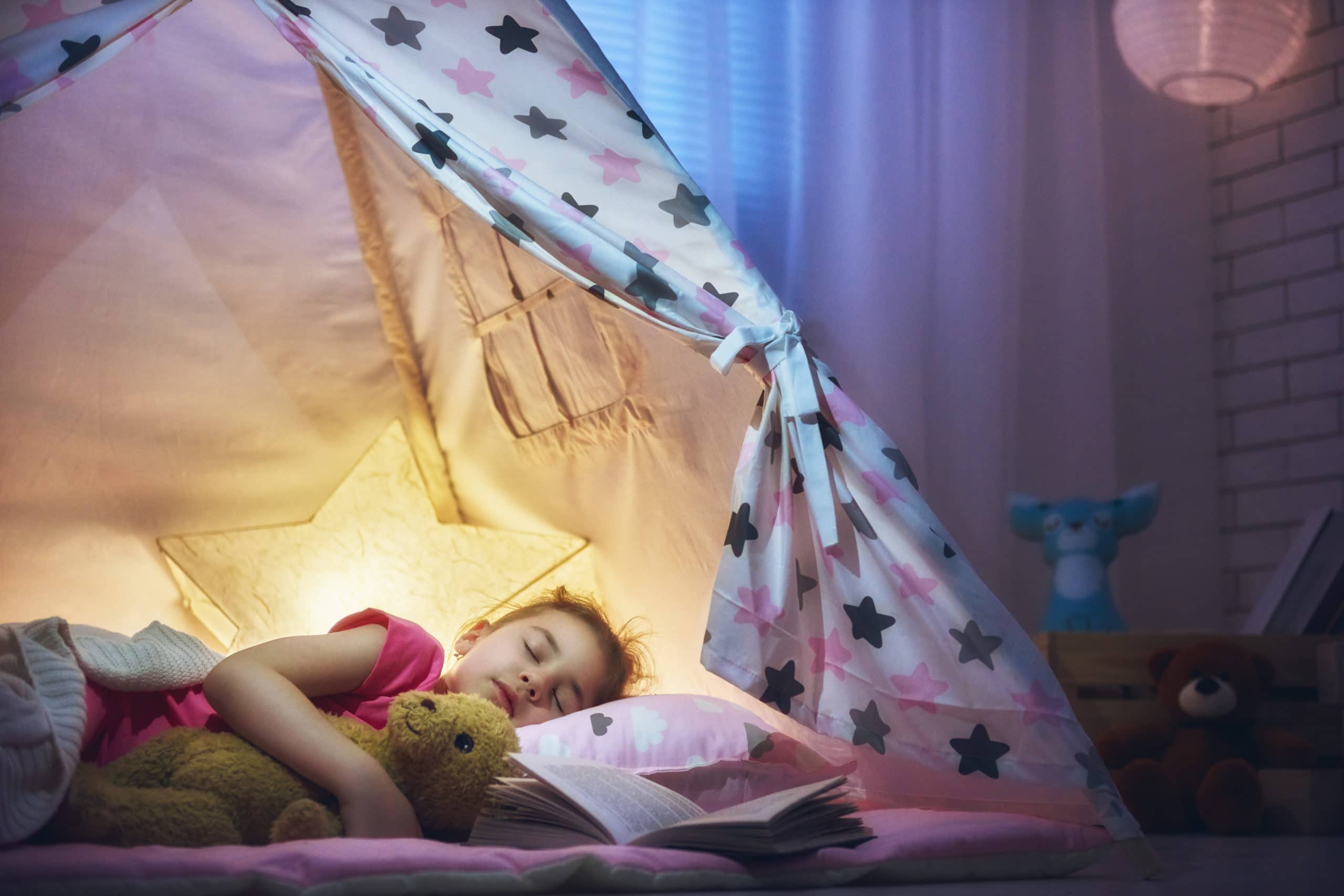 Mädchen schläft im Zelt