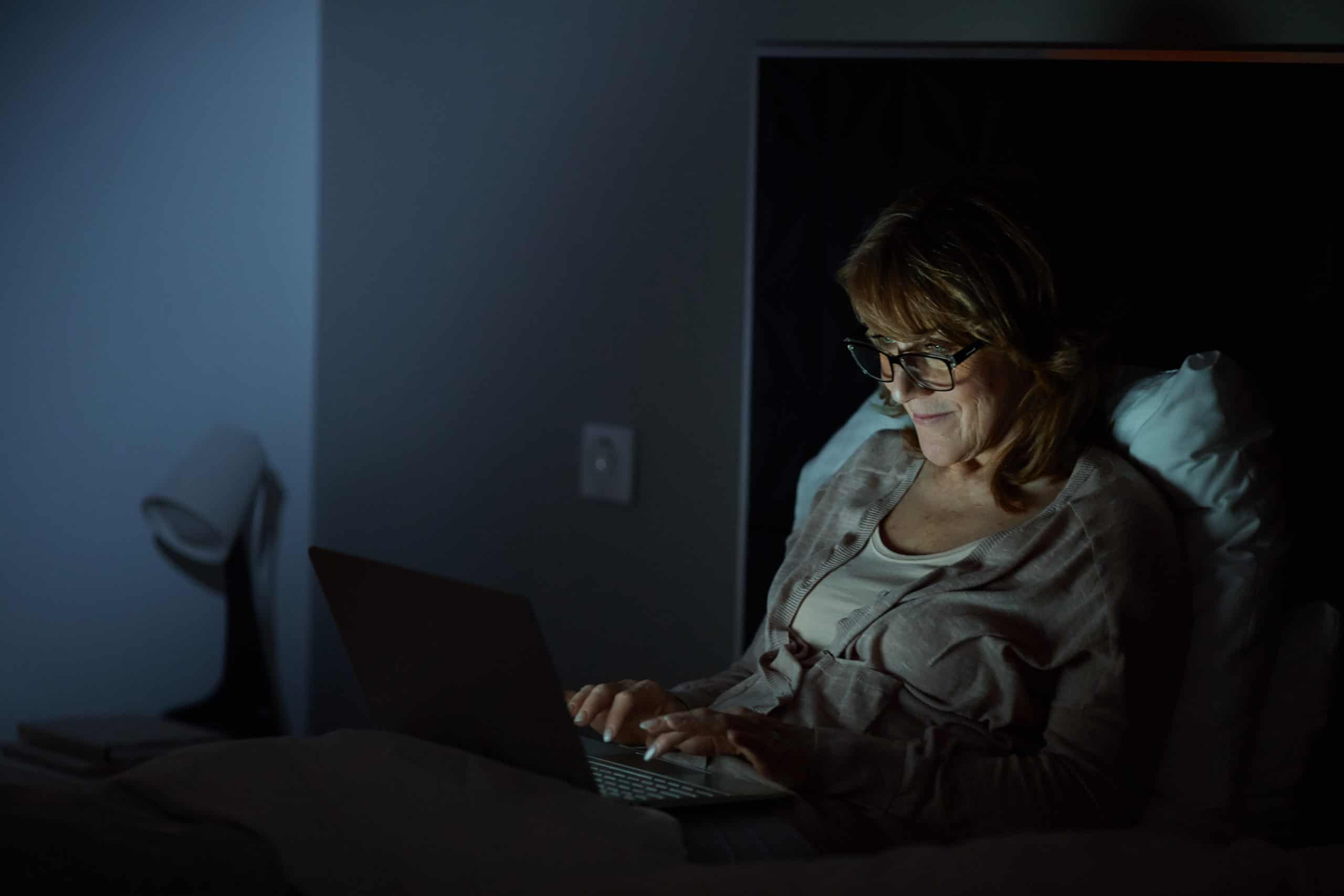 Frau mit Laptop im Bett