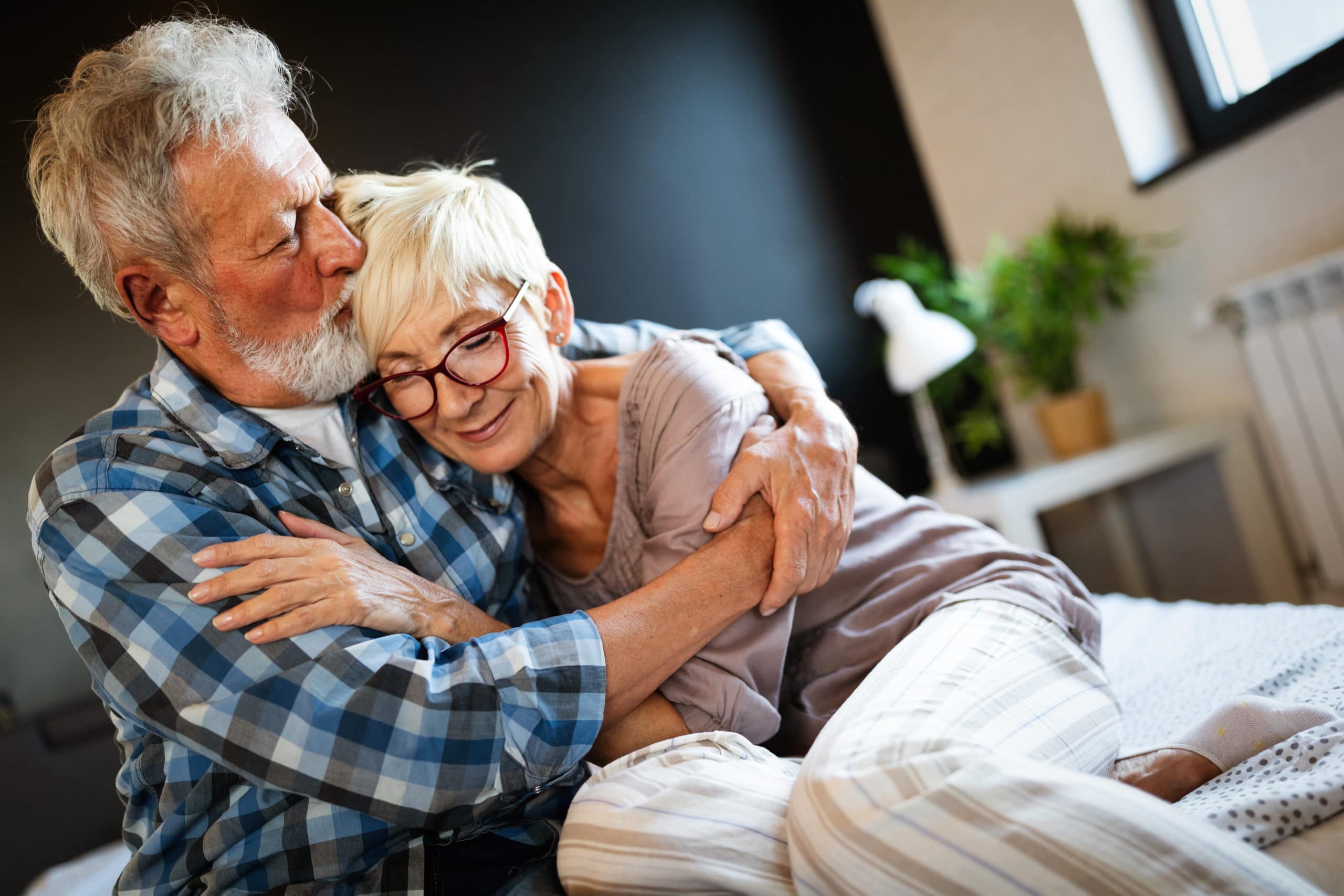 Glückliche lächelnde ältere Paar umarmen zusammen zu Hause