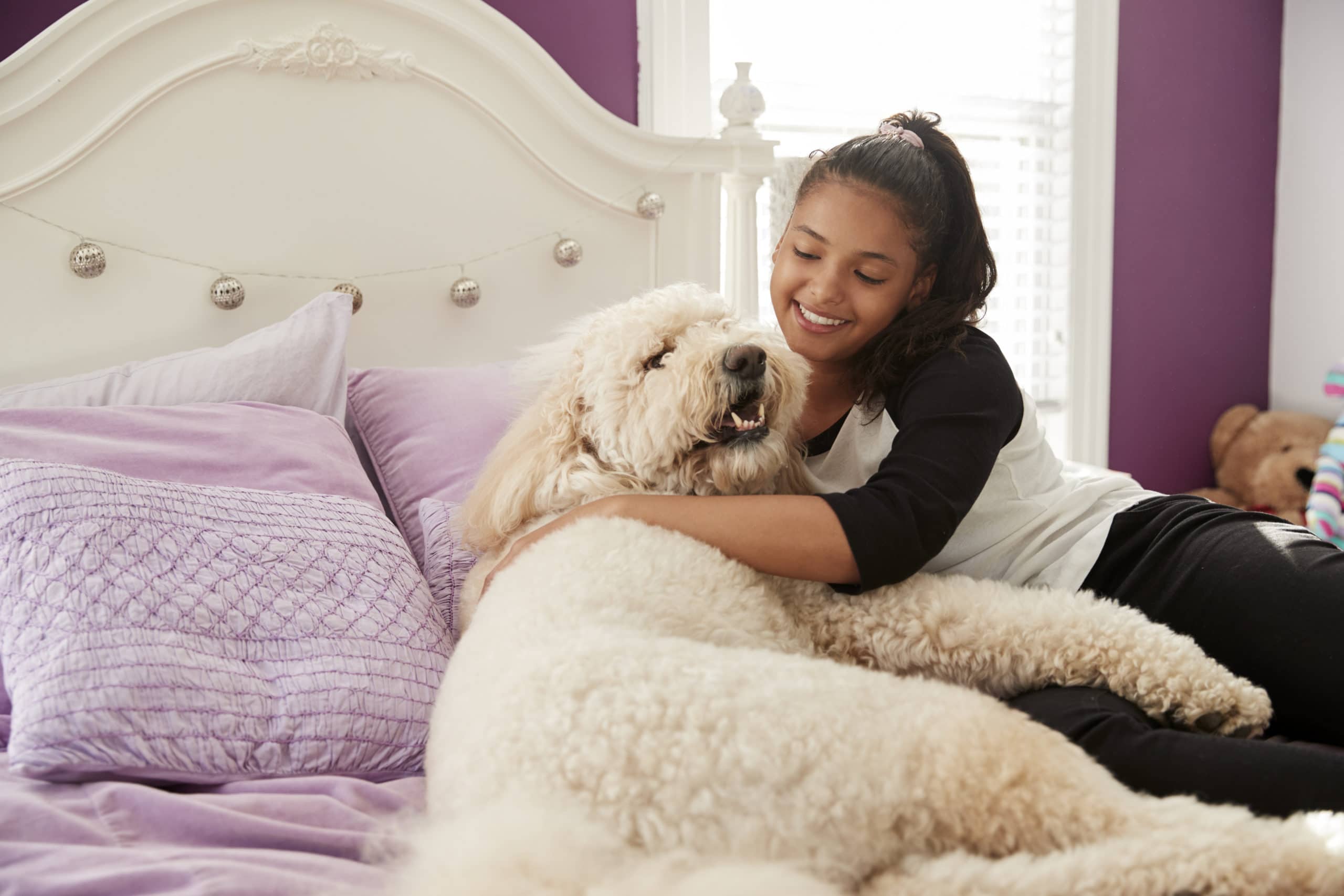 Mädchen Kuscheln Haustier Hund auf Ihr Bett