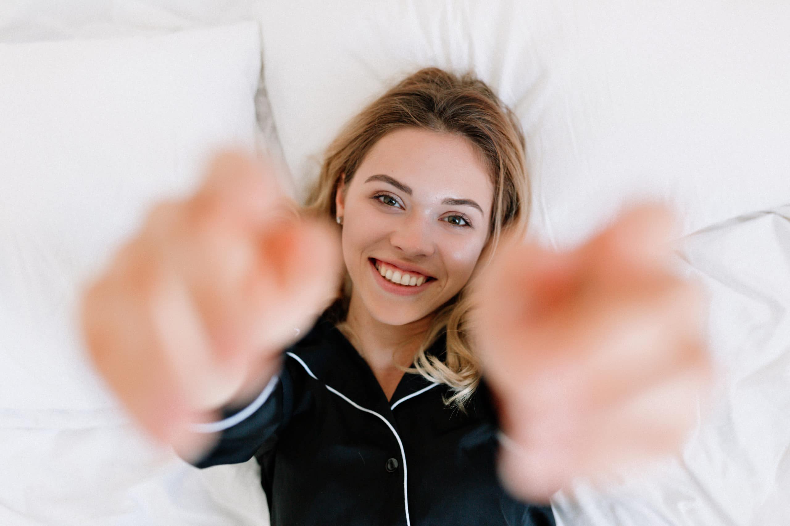 Porträt eines wundervollen blonden Mädchens auf dem Bett in einer modernen Wohnung am Morgen