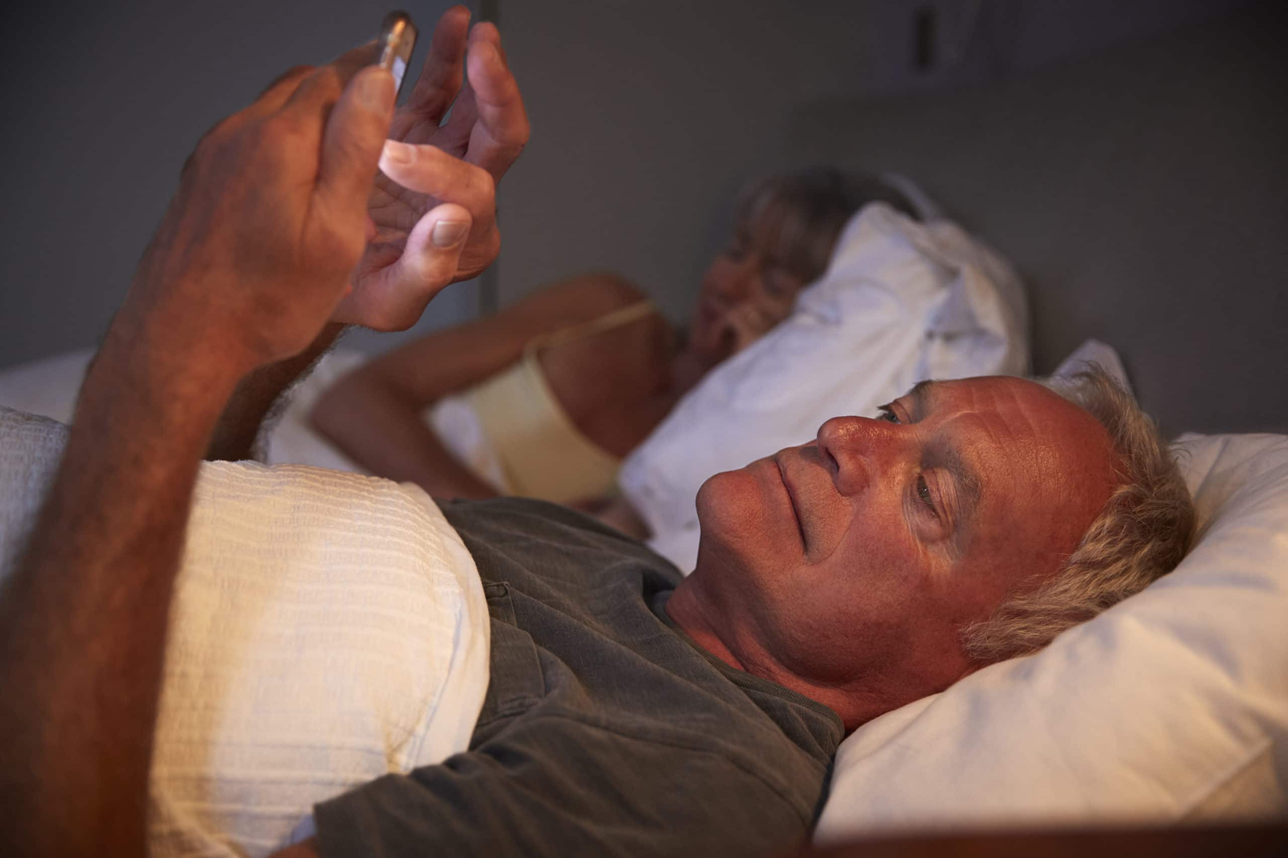Schlaflose Senior Mann im Bett bei Nacht mit Handy
