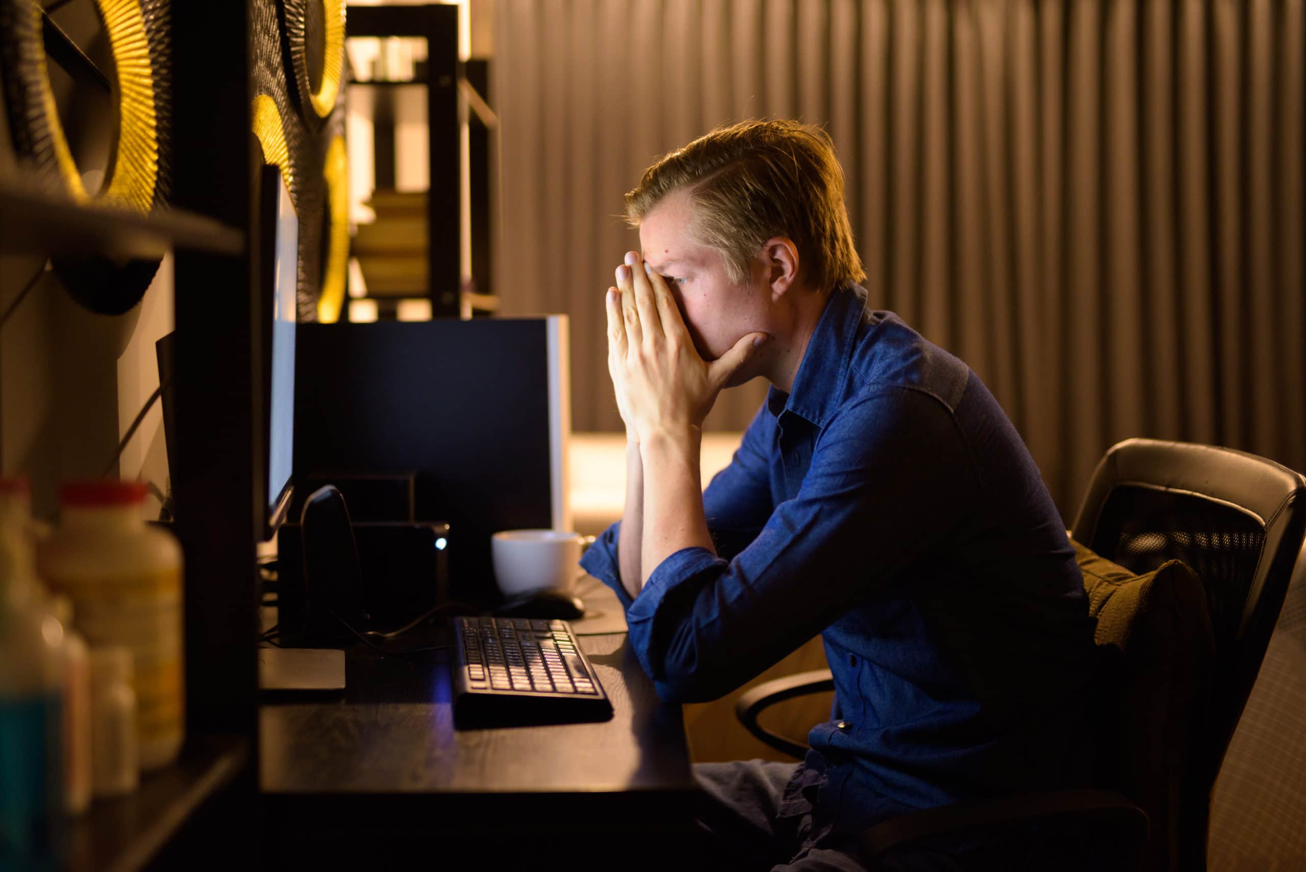 Stresste junge Geschäftsmann müde, während der Arbeit Überstunden zu Hause spät in der Nacht