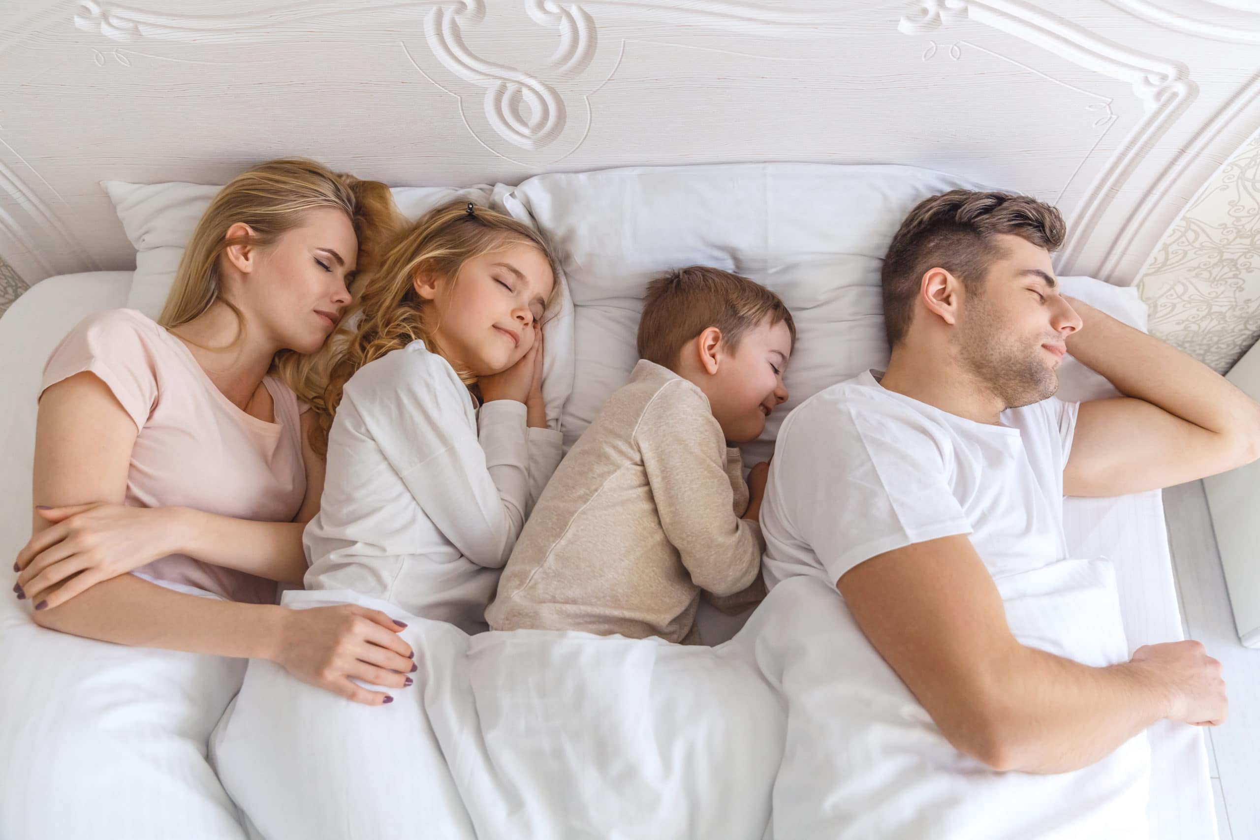 jungen Familie, die zusammen im Bett schläft