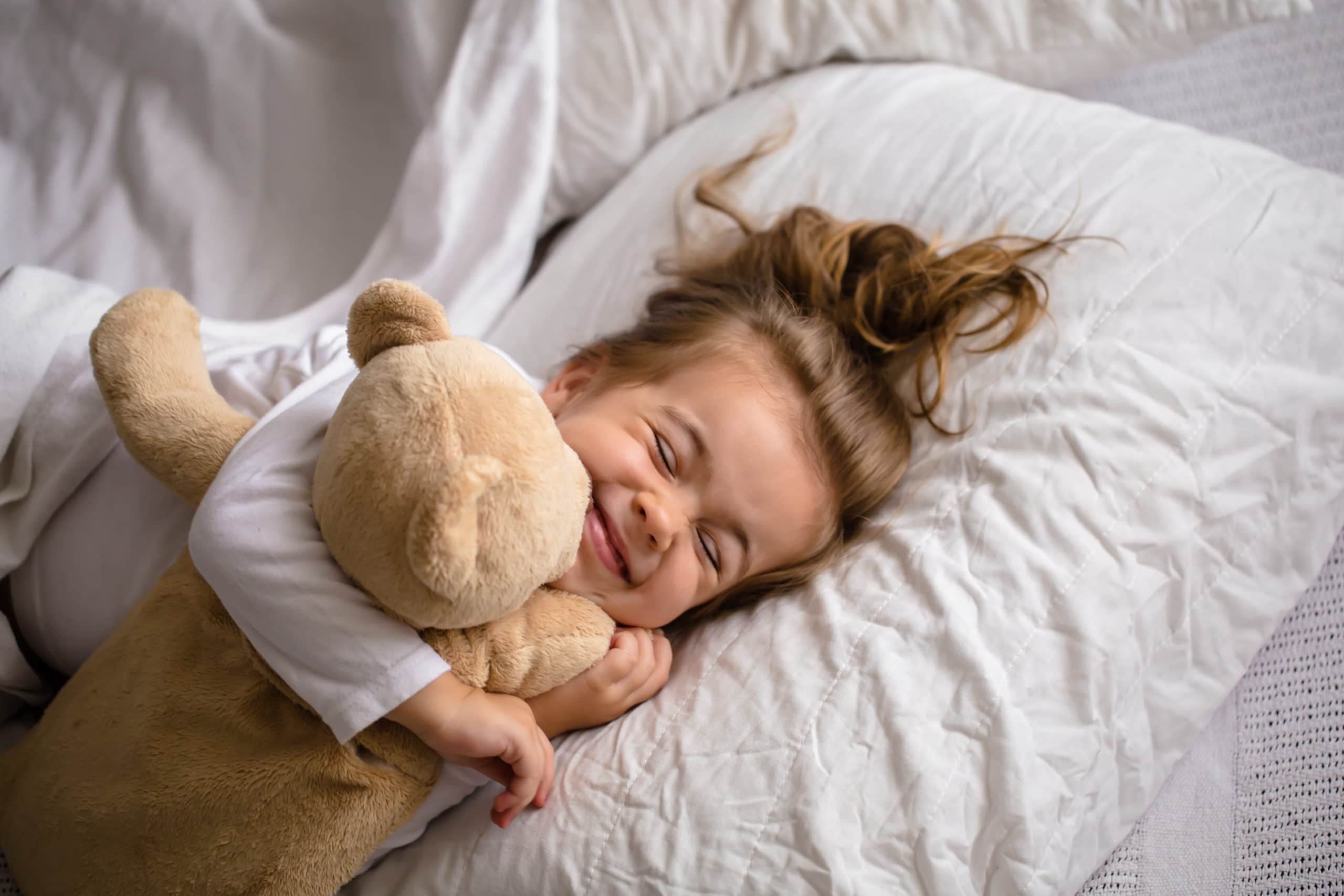 kleines Mädchen im Bett mit Stofftier