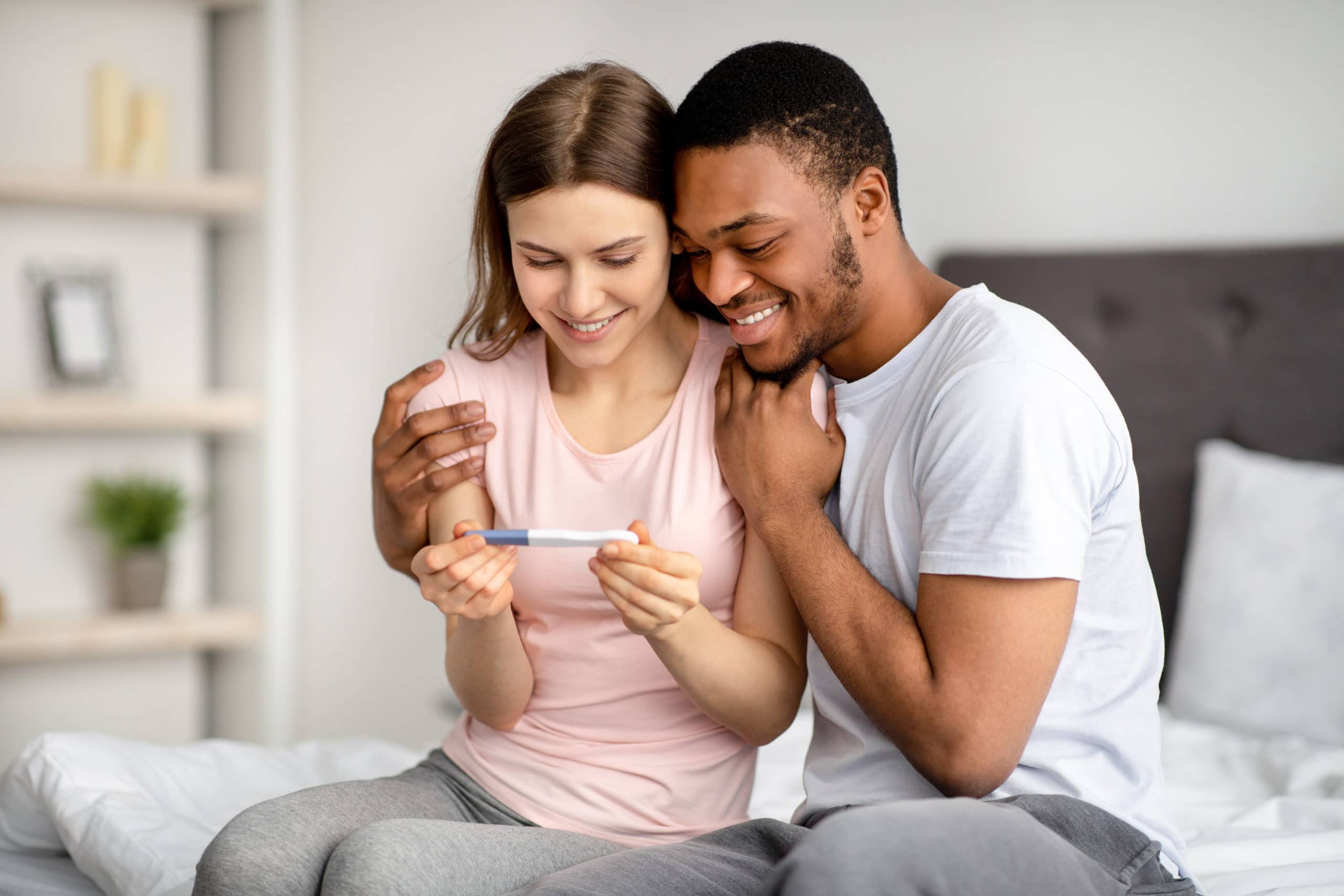Paar mit Blick auf einen positiven Schwangerschaftstest