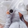 Frau mit Kaffee im Bett