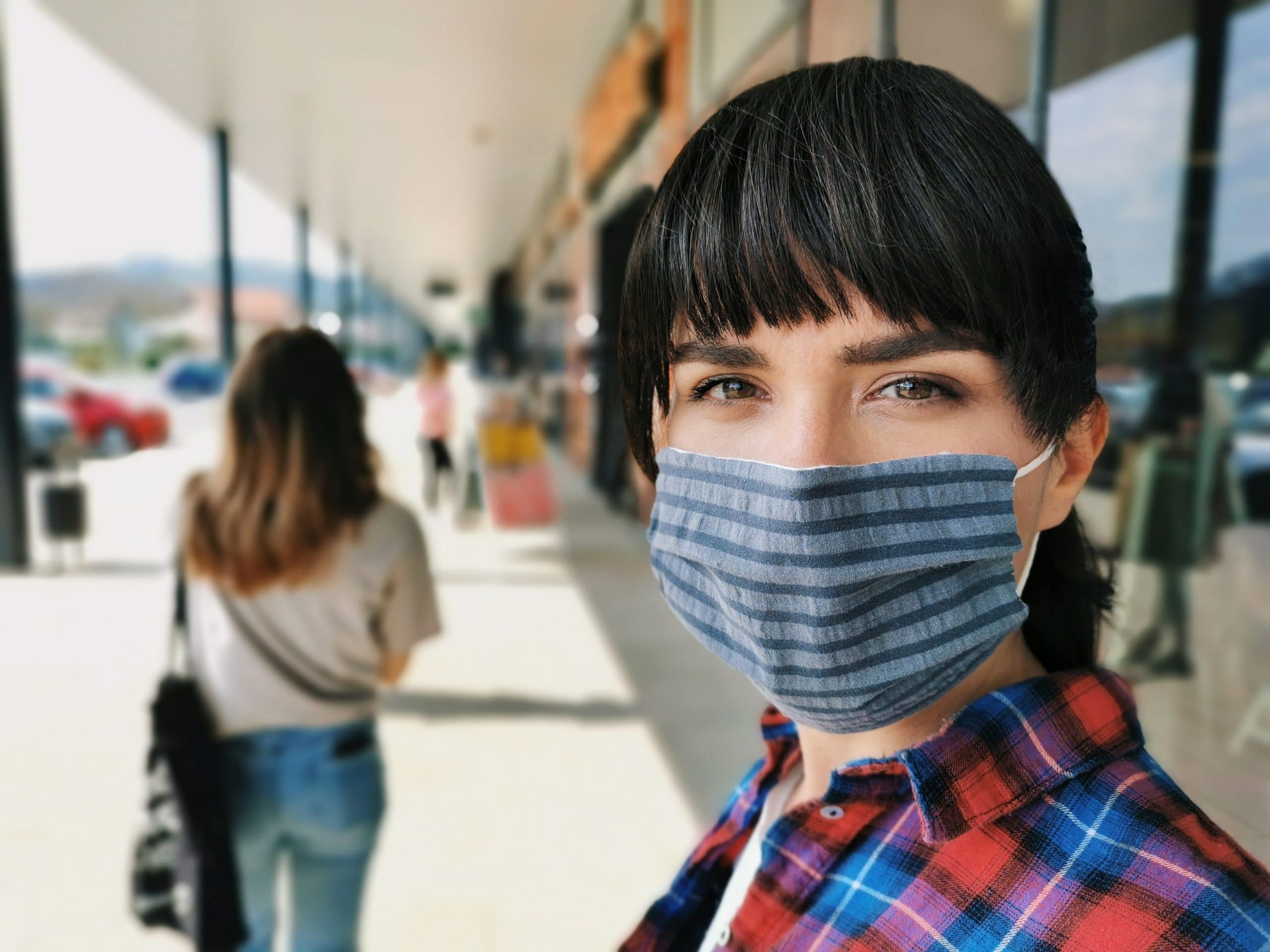 Porträt einer jungen Frau, die eine Maske trägt, während der COVID-19-Pandemie