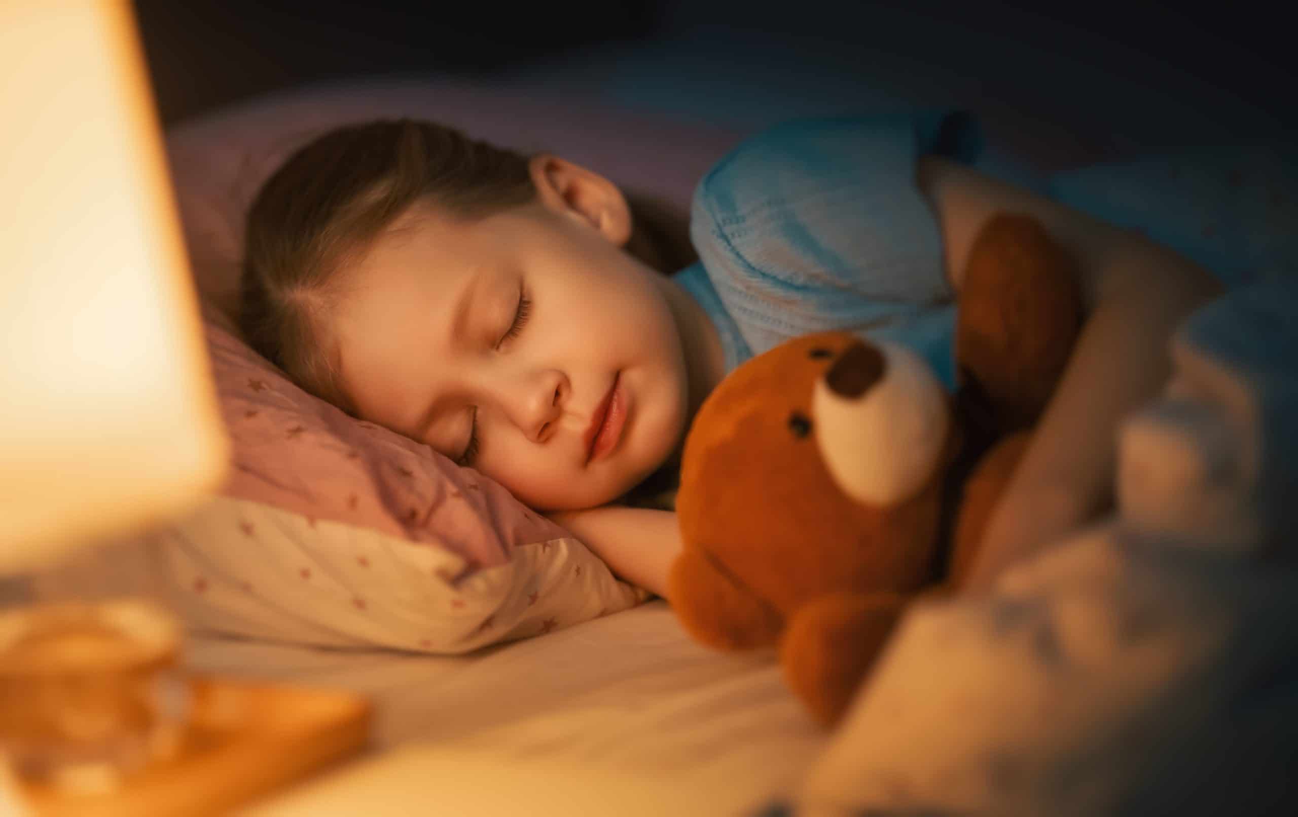 Kind schläft mit Teddy