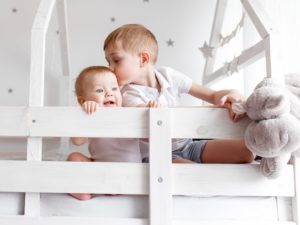 Kinder spielen im Bett im Kinderzimmer zu Hause