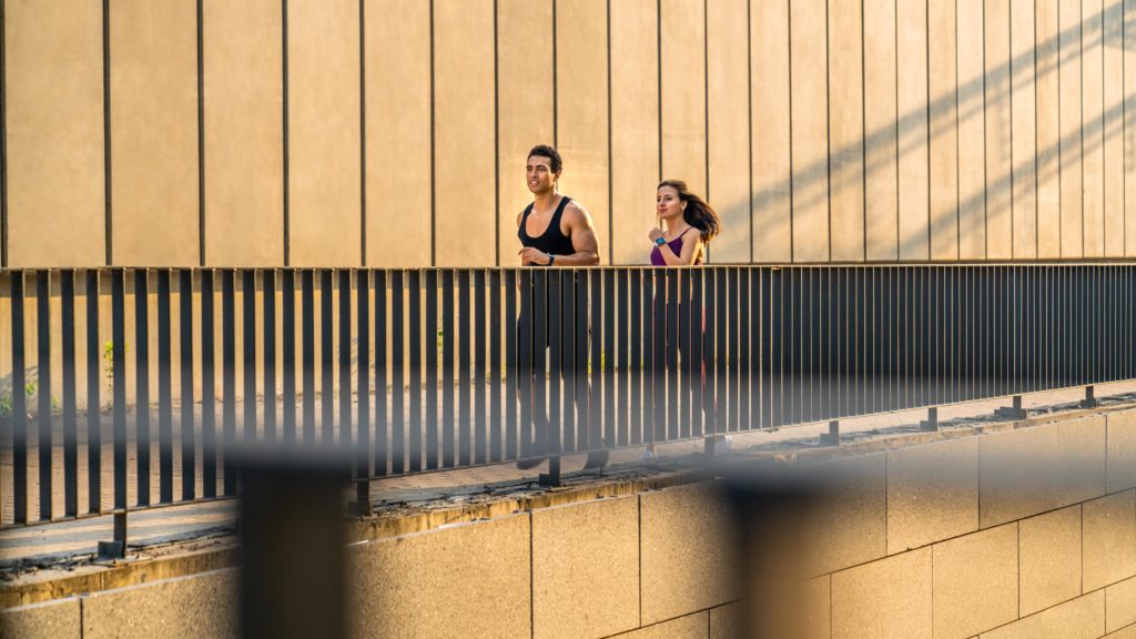 Junges sportliches Paar beim Laufen in der städtischen Umgebung